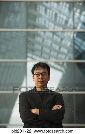 Stock Image - Asian businessman with arms crossed. Fotosearch