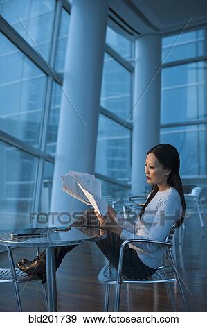 Stock Photo - Asian businesswoman looking at paperwork. Fotosearch
