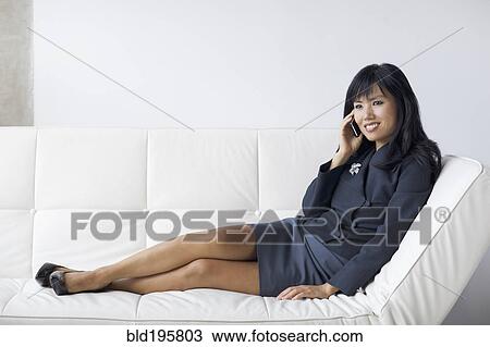 Asian businesswoman with feet up talking on cell phone View Large Photo Image Stock Image - Asian businesswoman with feet up talking on cell phone. Fotosearch