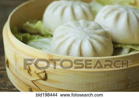 Picture - Asian dumpling in steamer with cabbage. Fotosearch