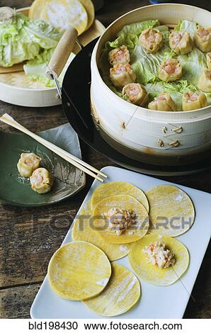 Stock Image - Asian dumpling in steamer with cabbage. Fotosearch