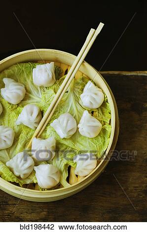 Asian dumpling in steamer with cabbage View Large Photo Image Stock Image - Asian dumpling in steamer with cabbage. Fotosearch