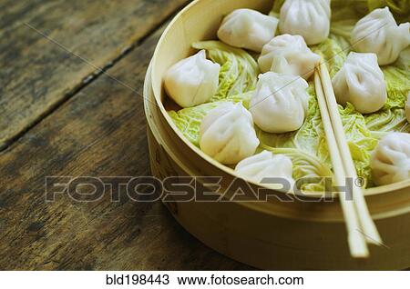 Stock Image - Asian dumpling in steamer with cabbage. Fotosearch