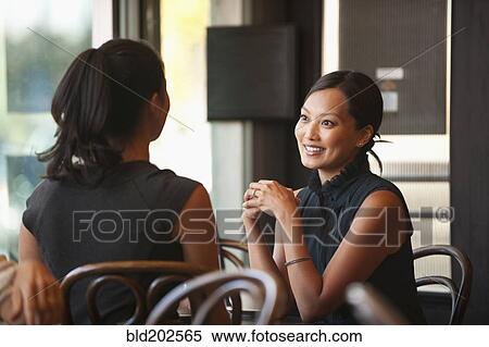 Asian friends sitting together in cafe View Large Photo Image Stock Photography - Asian friends sitting together in cafe. Fotosearch
