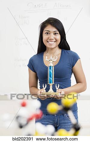 Asian high school student holding trophy in classroom View Large Photo Image Stock Image - Asian high school student holding trophy in classroom. Fotosearch