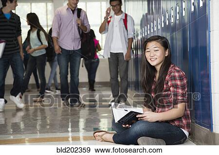 Stock Photo - Asian student sitting in high school corridor. Fotosearch