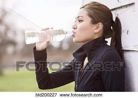 Asian woman drinking bottle of water View Large Photo Image Stock Photo - Asian woman drinking bottle of water. Fotosearch