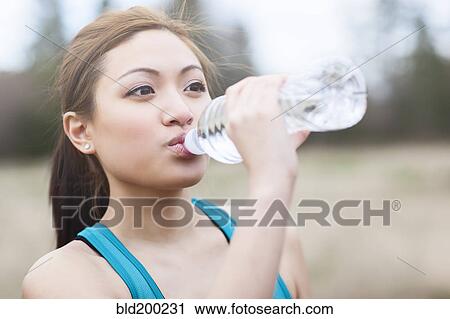 Stock Image - Asian woman drinking water. Fotosearch