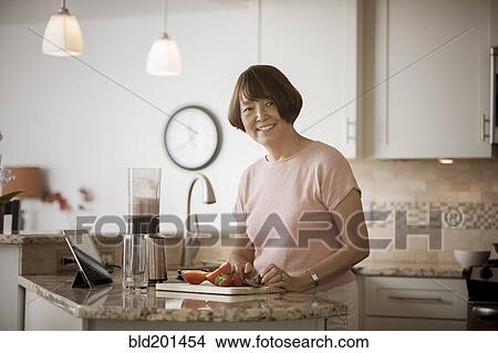 Picture - Asian woman preparing food. Fotosearch