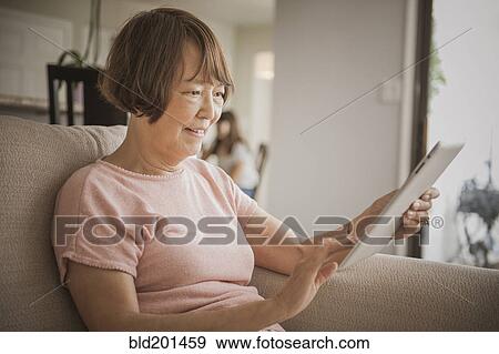 Stock Photo - Asian woman using digital tablet. Fotosearch