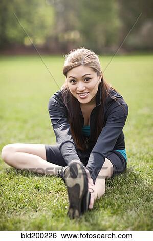 Stock Photograph - Asian woman warming up before exercise. Fotosearch