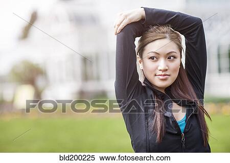 Stock Photography - Asian woman with arms above her head. Fotosearch