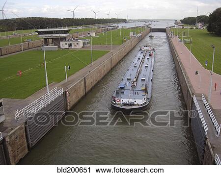 Stock Image - Barge traveling through canal. Fotosearch
