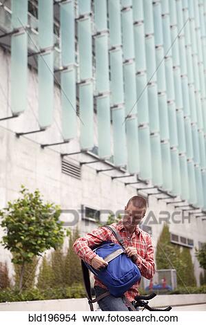 Picture - Bicycle messenger stopping on city street. Fotosearch