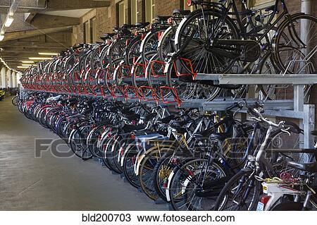 Bicycles parked in storage racks View Large Photo Image Stock Image - Bicycles parked in storage racks. Fotosearch