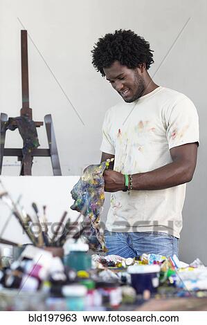 Stock Image - Black artist working in art studio. Fotosearch