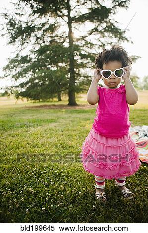 Black baby girl putting on sunglasses in park View Large Photo Image Stock Photography - Black baby girl putting on sunglasses in park. Fotosearch
