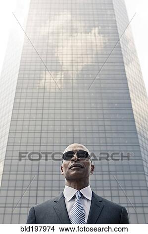 Picture - Black businessman standing near highrise. Fotosearch