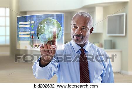 Stock Image - Black businessman using digital display in office. Fotosearch