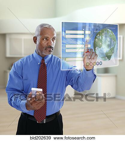 Stock Photo - Black businessman using digital display in office. Fotosearch