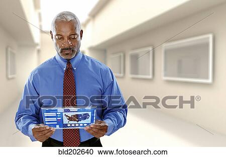 Black businessman using digital tablet in office View Large Photo Image Stock Image - Black businessman using digital tablet in office. Fotosearch