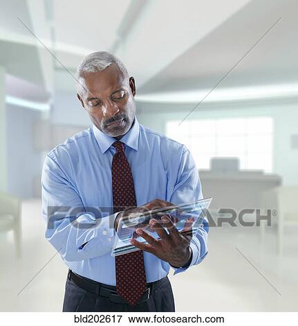 Stock Photo - Black businessman using digital tablet in a lab. Fotosearch
