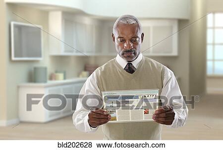 Stock Photo - Black businessman using digital tablet in office. Fotosearch