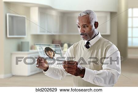 Black businessman using digital tablet in office View Large Photo Image Stock Photo - Black businessman using digital tablet in office. Fotosearch
