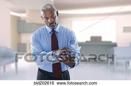 Stock Photograph - Black businessman using digital tablet. Fotosearch