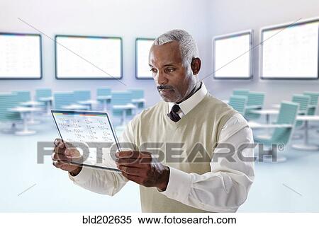 Stock Photography - Black businessman using digital tablet in conference room. Fotosearch