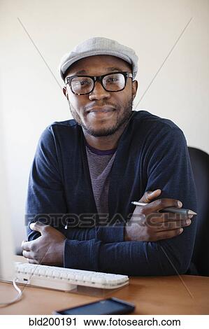 Stock Image - Black businessman working at desk. Fotosearch