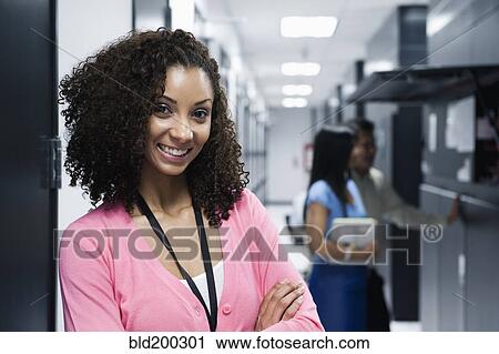 Stock Image - Black businesswoman standing in server room. Fotosearch