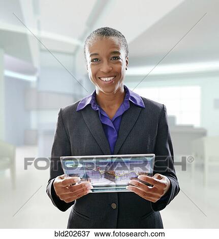 Stock Photo - Black businesswoman using digital tablet in office. Fotosearch