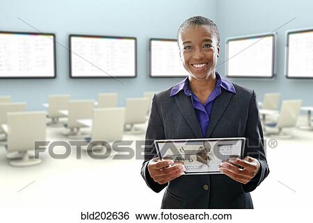 Stock Photograph - Black businesswoman using digital tablet in conference room. Fotosearch