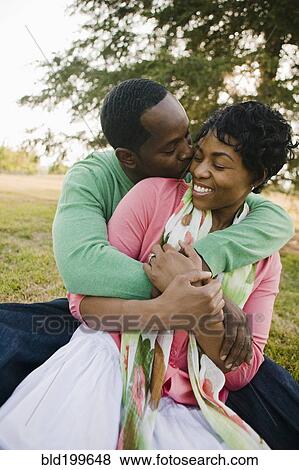 Stock Photo - Black couple hugging in park. Fotosearch