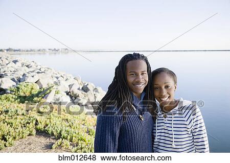 Stock Photo - Black couple hugging near bay. Fotosearch