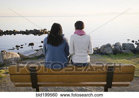 Black couple sitting on bench near shore View Large Photo Image Stock Image - Black couple sitting on bench near shore. Fotosearch