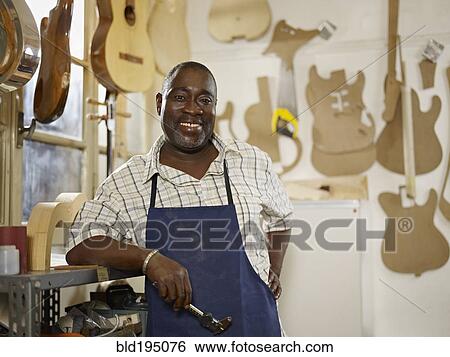 Black craftsman in guitar workshop View Large Photo Image Stock Photograph - Black craftsman in guitar workshop. Fotosearch