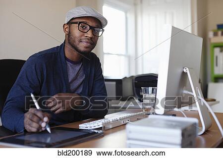 Stock Photo - Black designer working at desk. Fotosearch