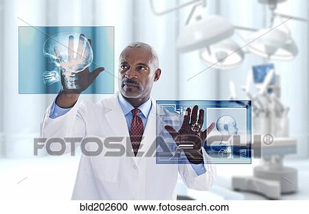 Stock Image - Black doctor looking at digital display in doctor's office. Fotosearch