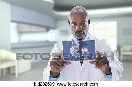 Stock Photo - Black doctor using digital display in doctor's office. Fotosearch