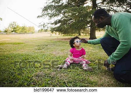 Black father and daughter enjoying the park View Large Photo Image Stock Photo - Black father and daughter enjoying the park. Fotosearch