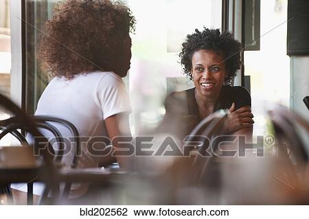 Black friends sitting together in cafe View Large Photo Image Stock Image - Black friends sitting together in cafe. Fotosearch