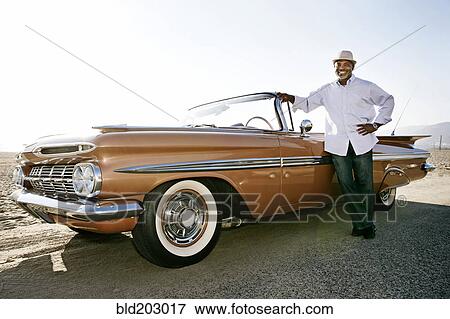 Black man leaning on convertible View Large Photo Image Stock Photo - Black man leaning on convertible. Fotosearch