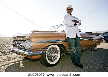 Black man leaning on convertible View Large Photo Image Stock Photograph - Black man leaning on convertible. Fotosearch