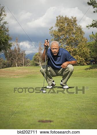 Stock Image - Black man playing golf. Fotosearch