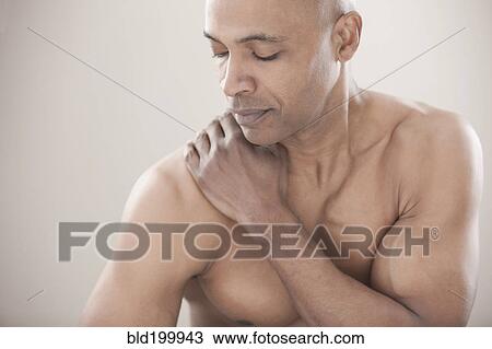 Stock Image - Black man rubbing his shoulders. Fotosearch