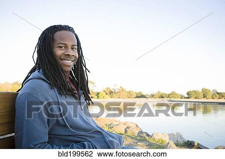 Black man sitting near shore View Large Photo Image Stock Image - Black man sitting near shore. Fotosearch
