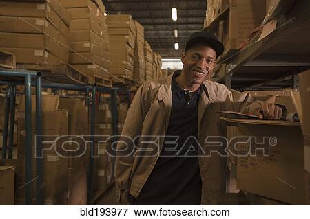 Black man working in warehouse View Large Photo Image Stock Photo - Black man working in warehouse. Fotosearch