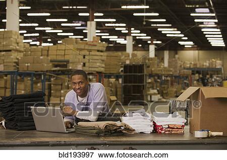 Stock Photo - Black man working in warehouse. Fotosearch